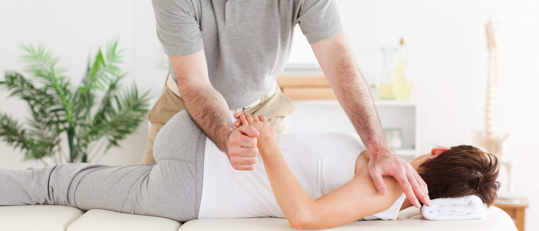 Masseur stretching woman's arm